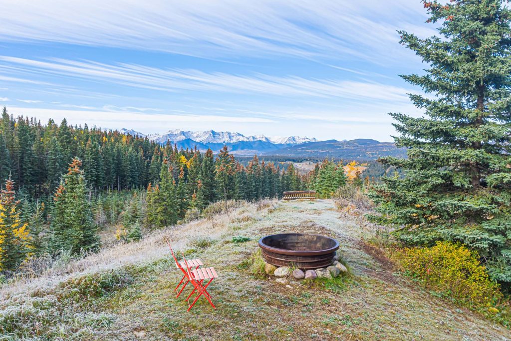 firepit and chairs overlooking view of rocky mountains at a B&B